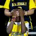 Michigan fan and eight-year-old Robert Davis Jr. shields his eyes with Rebecca Kam's hands at Crisler Arena on Monday, April 8. Daniel Brenner I AnnArbor.com