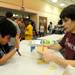 King elementary 4th grader Aman Panjabi, left, braces himself as Huron High School junior Eylam Morag shows how a balloon won't pop when forced against many nails to demonstrate the effect of the distribution of energy during a demo at the Washtenaw Elementary Science Olympiad. Angela J. Cesere  