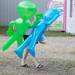 A woman holds two alien blowup doles as she walks through the Chelsea Community Fair Wednesday, August 21. 
Courtney Sacco I AnnArbor.com 